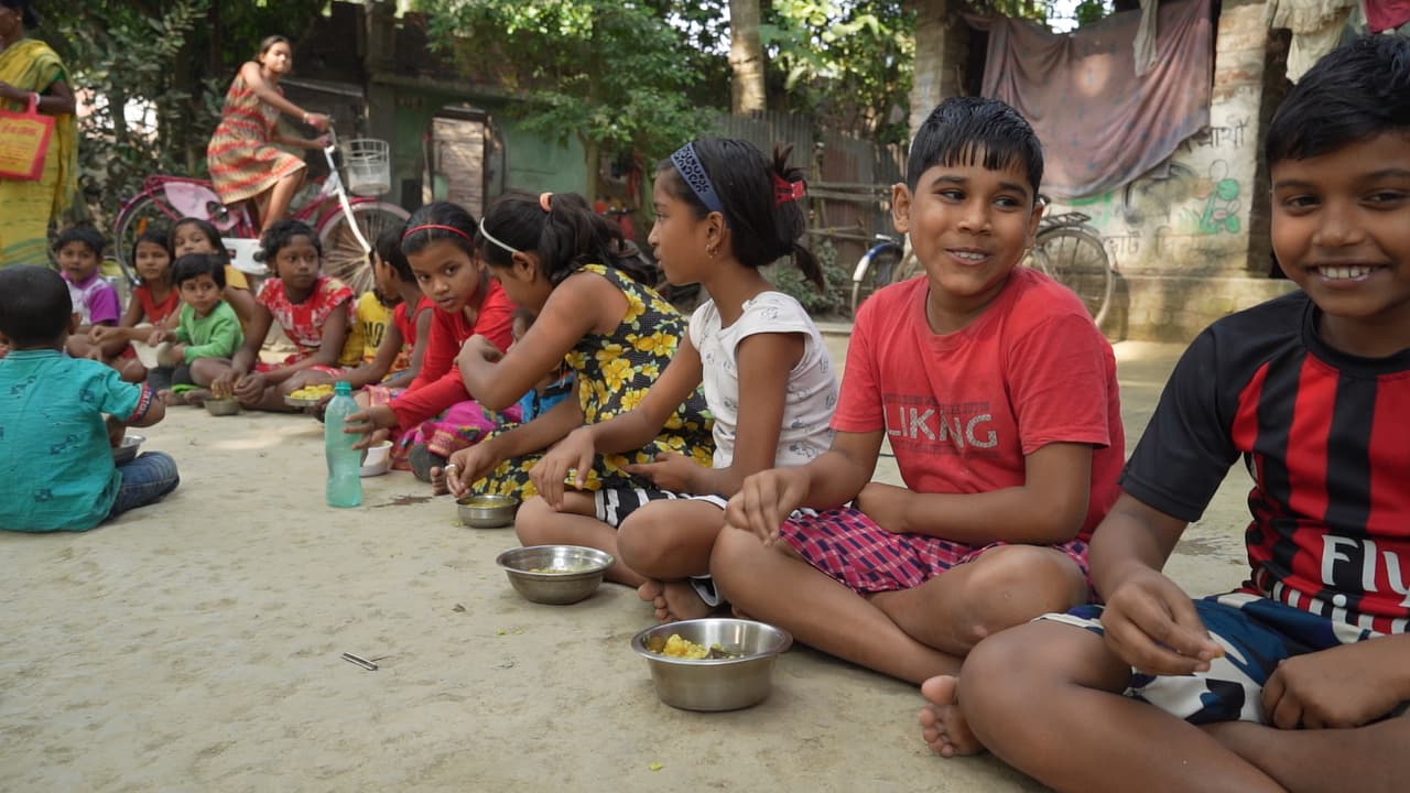 Children sharing freshly served meals in Mayapur
